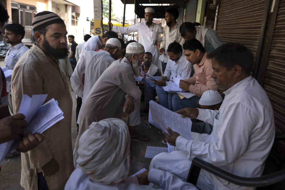 Muslims check for their names in voters' list as they arrive to vote in Nahal village, Uttar Pradesh state, India, on April 26, 2024. (AP Photo/Altaf Qadri)