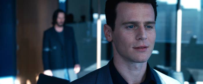 Groff looks in the distance as Reeves stands behind him