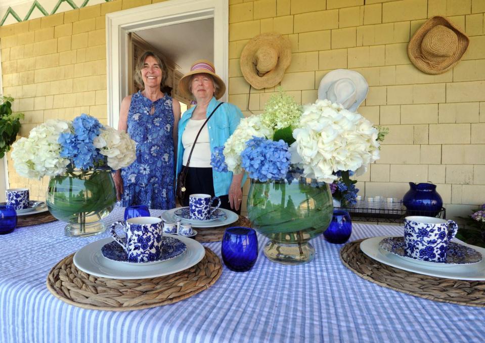 Duxbury Rural & Historical Society members Sally Redmond, left, and Jayne O'Farrell stand near a table featuring hydrangea arrangements at the Nathaniel Winsor Jr. House in Duxbury during the hydrangea garden tour hosted by the Community Garden Club of Duxbury, Tuesday, July 12, 2022.