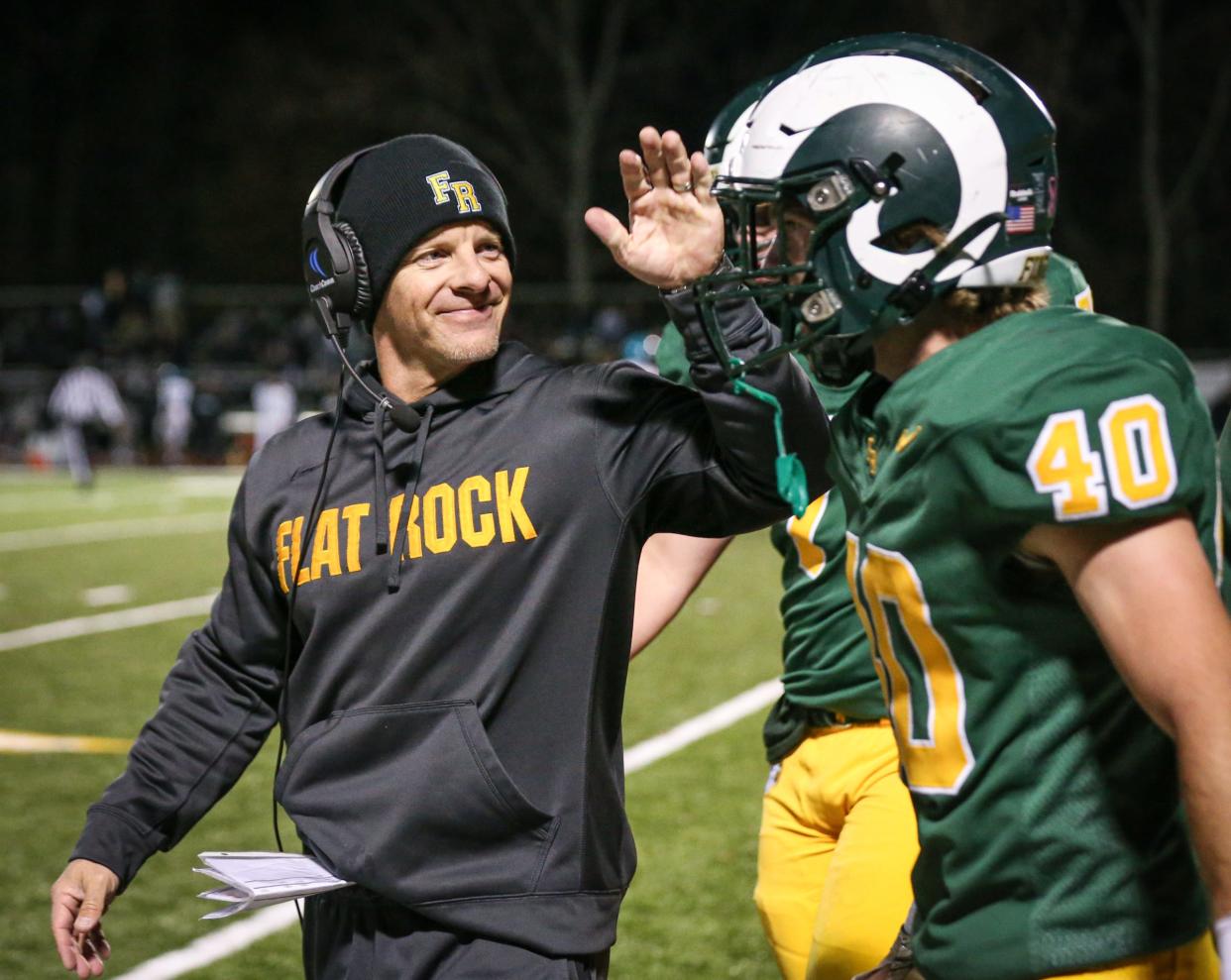 Flat Rock coach Buck Reaume congratulates Brian Booms on his 2-point conversion during a 42-6 win over Summit Academy in the Division 5 District finals.
