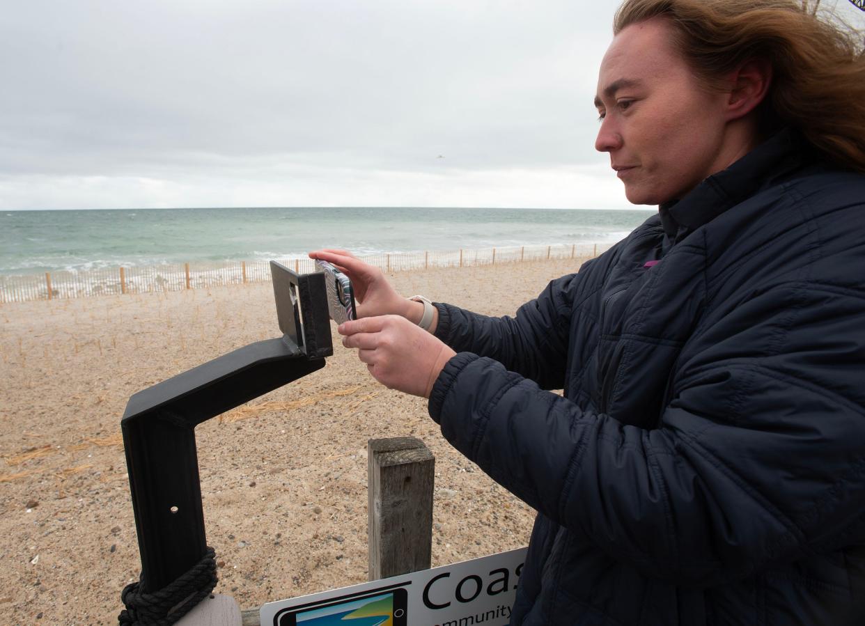 Graduate student Rilee Thomas uses a support on Wednesday to snap a photo in each direction of the coastline at Town Neck Beach in Sandwich. The images are then sent via a QR code to a data bank that monitors erosion at the beach. Thomas is working with Woods Hole Oceanographic Institution scientist Sarah Das.