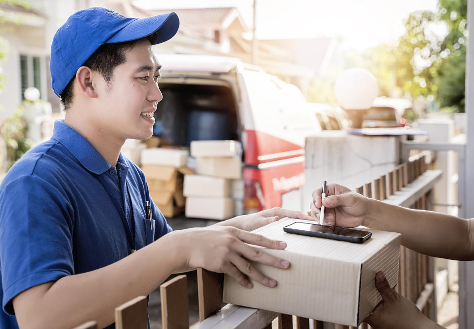 An Asian man delivering a package.