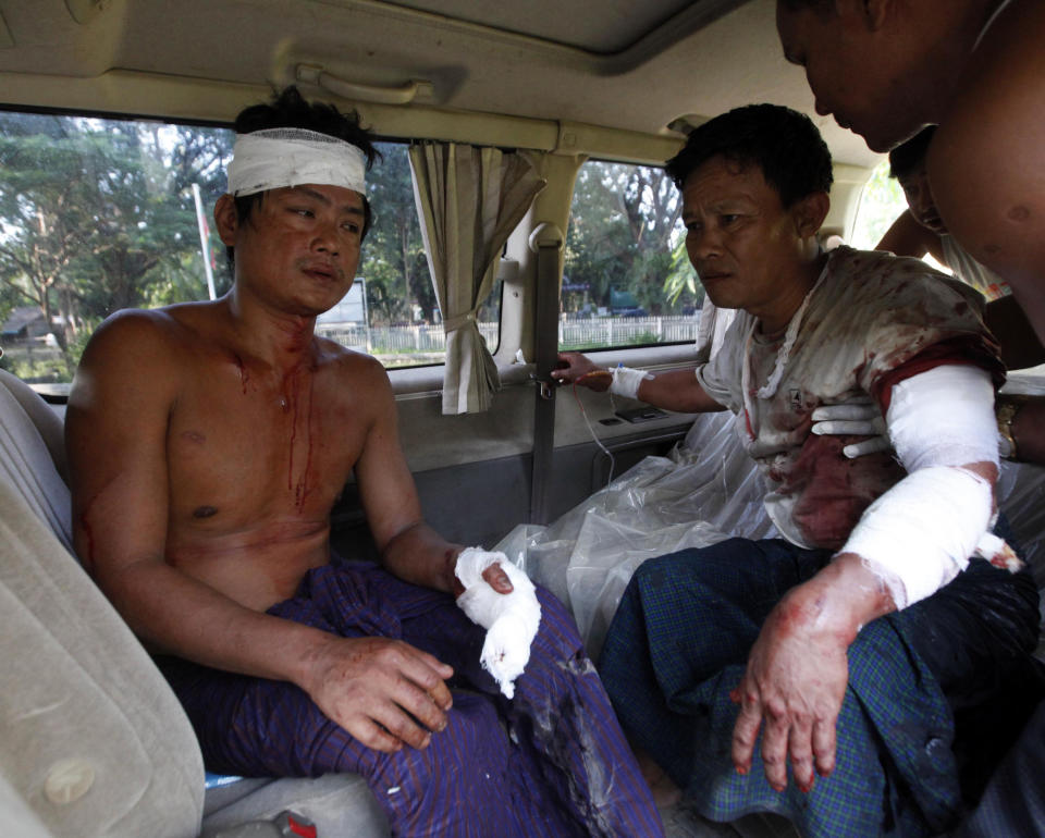 In this Tuesday, Oct. 1, 2013 photo, two injured Rakhine men sit in a car as they prepare to go to hospital in Thandwe, Rakhine State, western Myanmar. Buddhist mobs killed a 94-year-old Muslim woman and torched more than 70 homes on Tuesday as sectarian violence again gripped Myanmar's Rakhine state despite a visit by President Thein Sein, officials and residents said. (AP Photo/Khin Maung Win)