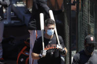 FILE - In this Sunday, July 5, 2020, file photo, San Francisco Giants' Buster Posey carries his bats during a baseball practice in San Francisco. Posey is the latest big-name player to skip this season because of concerns over the coronavirus pandemic. Posey announced his decision on Friday, July 10, 2020. He says his family finalized the adoption of identical twin girls this week. The babies were born prematurely and Posey said after consultations with his wife and doctor he decided to opt out of the season. (AP Photo/Jeff Chiu, File)