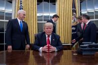 US President Donald Trump (C) got to work right off the bat, signing a stack of executive orders and formal cabinet nominations