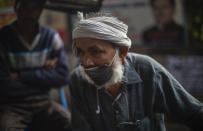 A rickshaw puller waits for passengers to ferry them on his rickshaw while wearing a protective mask amid coronavirus fear in New Delhi.