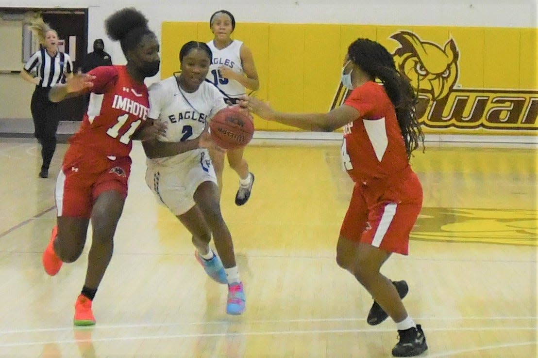 Paul VI sophomore Sharia Baynes fights through the double team of Imhotep Charter guards Samya Stevens and Senaya Parker