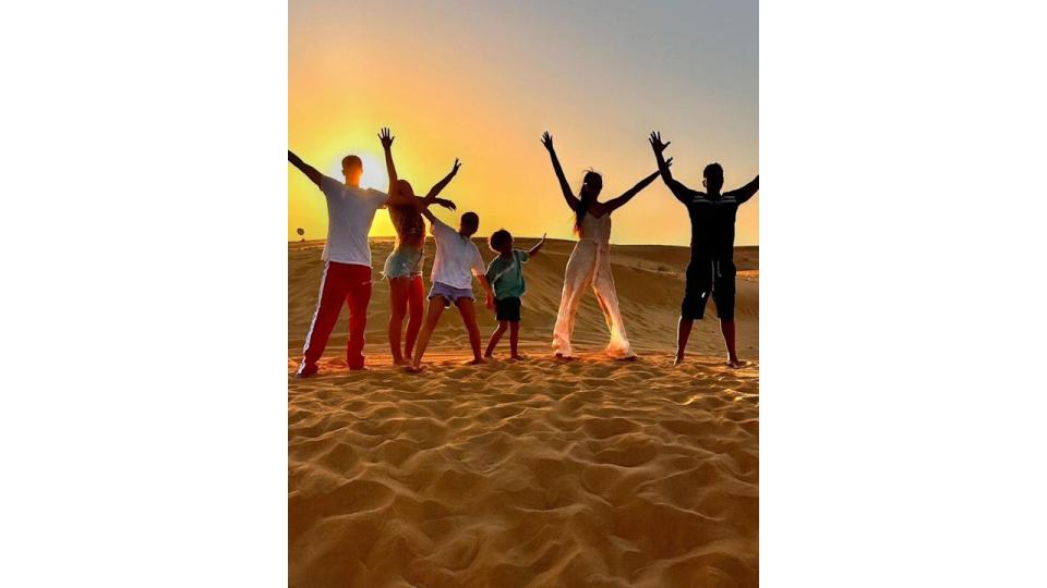 Peter Andre and his family posing on a sand dune 