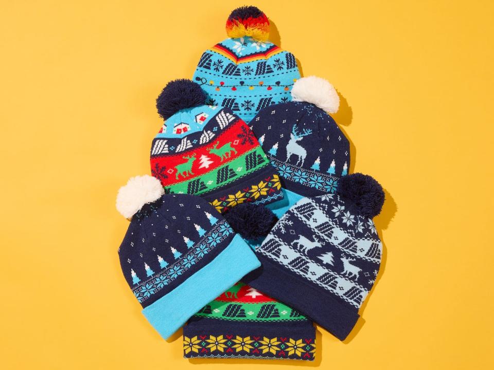 holiday themed hats stacked on top of each other on a yellow background