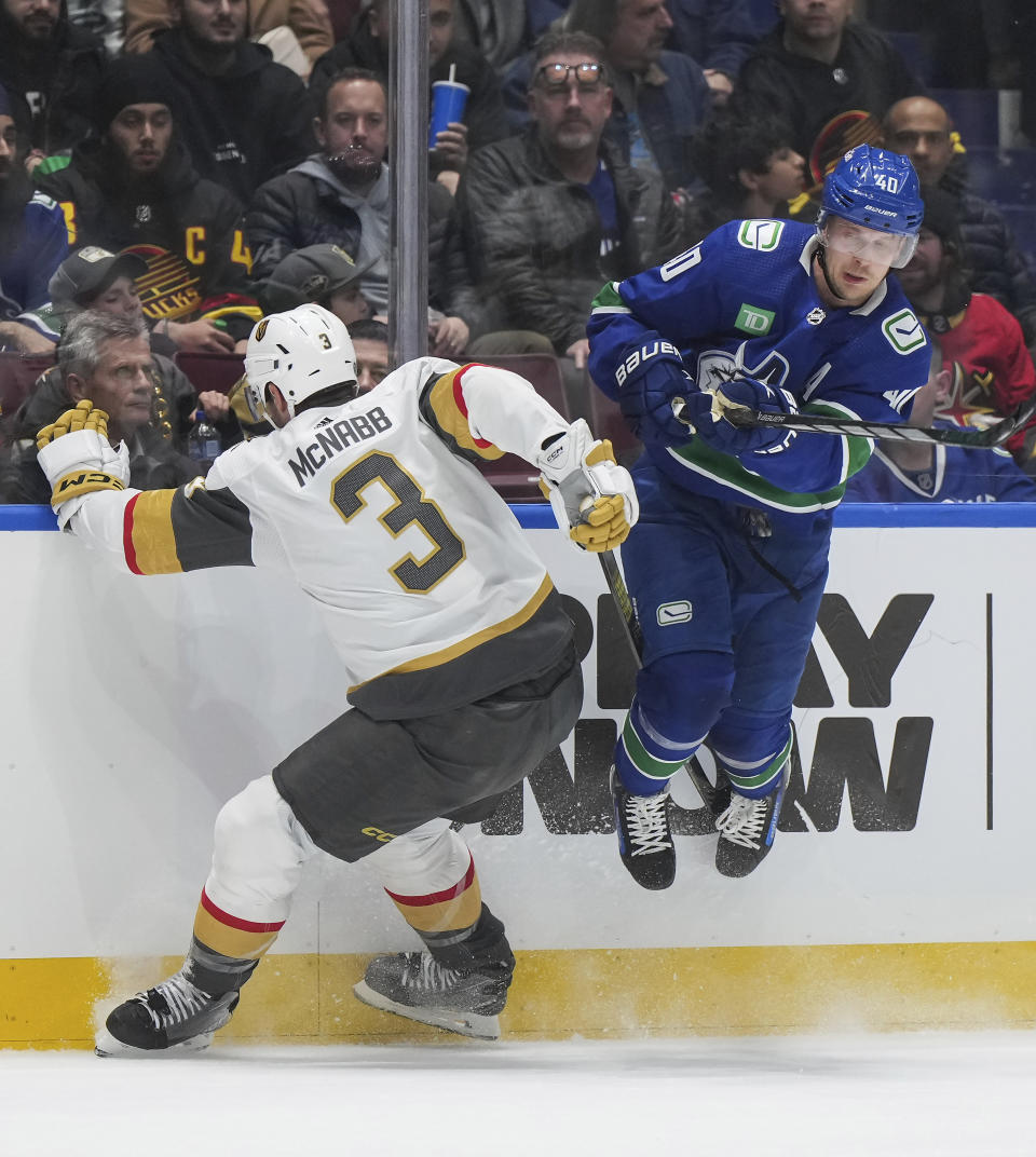 Vancouver Canucks' Elias Pettersson, right, avoids a check by Vegas Golden Knights' Brayden McNabb during the first period of an NHL hockey game Thursday, Nov 30, 2023, in Vancouver, British Columbia. (Darryl Dyck/The Canadian Press via AP)