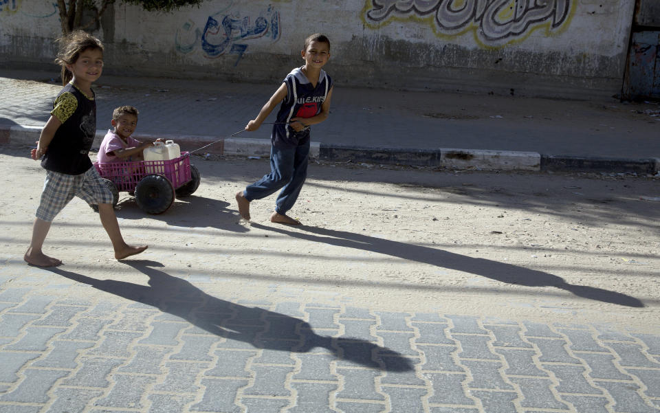 Palestinian children push a wagon with containers of drinkable water to their homes in Gaza City, Sunday, May. 12, 2019. Demand on potable water increases during the Muslim holy fasting month of Ramadan. More than 95% of Gaza's water is salty and contaminated. (AP Photo/Hatem Moussa)