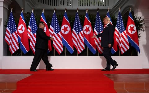 U.S. President Donald Trump and North Korean leader Kim Jong Un prepare to shake hands at the Capella Hotel on Sentosa island in Singapore - Credit: Reuters