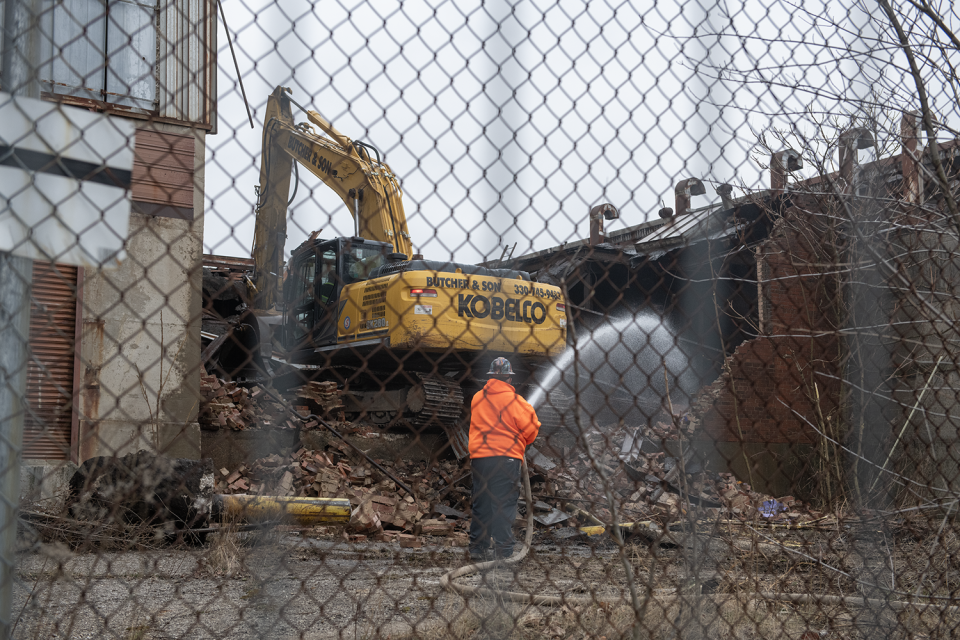 A demolition worker keeps the dust down Thursday as Butcher & Son Excavating begins to tear down the former Atlantic Foundry Co.  between Annadale Avenue and Beaver Street in Akron.