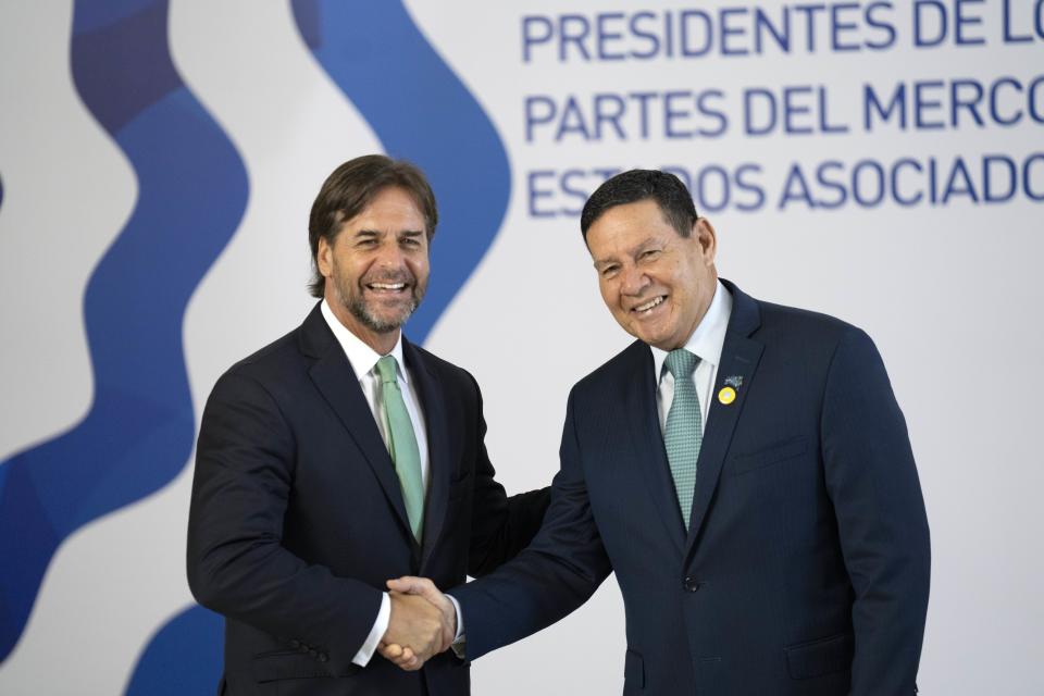 Uruguay's President Luis Lacalle Pou, left, greets Brazil's Vice President Hamilton Mourao at the Mercosur trade bloc summit in Montevideo, Uruguay, Tuesday, Dec. 6, 2022. (AP Photo/Matilde Campodonico)