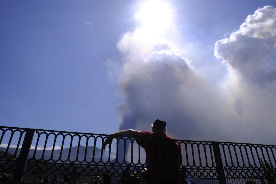 A man looks towards a volcano as it continues to erupt in El Paso on the canary island of La Palma, Spain, Saturday Oct. 9, 2021. A new lava flow has belched out from the La Palma volcano and it threatens to spread more destruction on the Atlantic Ocean island where molten rock streams have already engulfed over 1,000 buildings. The partial collapse of the volcanic cone overnight sent a new lava stream Saturday heading toward the western shore of the island. (AP Photo/Daniel Roca)