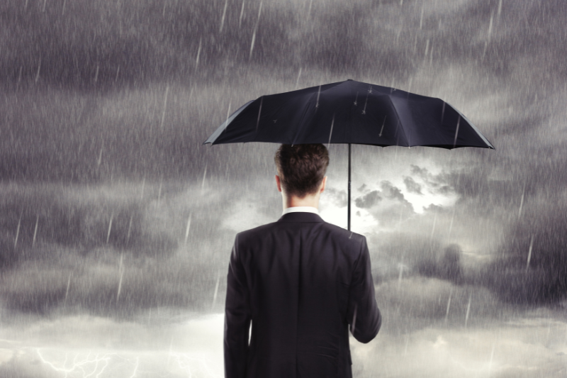 Man Holding Umbrella in Storm