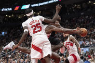 Cleveland Cavaliers' Caris LeVert, second from right, tries to force his way through the Toronto Raptors defense during second-half NBA basketball game action in Toronto, Monday, Nov. 28, 2022. (Chris Young/The Canadian Press via AP)