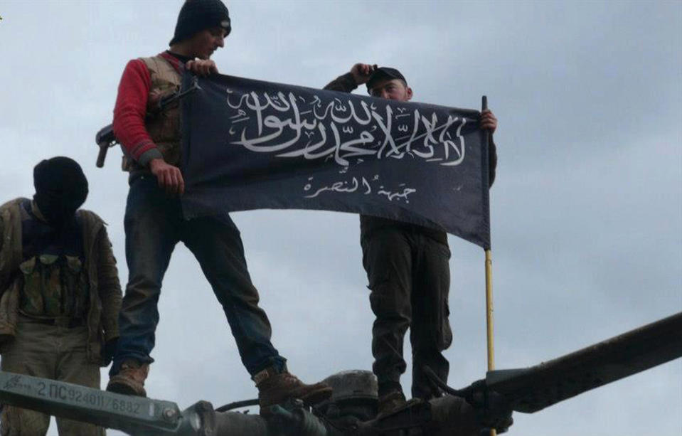 FILE - This Friday, Jan. 11, 2013 file citizen journalism image provided by Edlib News Network, an anti-Bashar Addad group, ENN, which has been authenticated based on its contents and other AP reporting, shows rebels from al-Qaida affiliated Jabhat al-Nusra waving their brigade flag as they step on the top of a Syrian air force helicopter, at Taftanaz air base that was captured by the rebels, in Idlib province, northern Syria. A sharp increase in the number of al-Qaida linked fighters joining the fight against President Bashar Assad in Syria is threatening to spill over the borders and prompting the Jewish state to re-evaluate its policy of neutrality in the civil war next door, a senior Israeli intelligence official warned on Friday, Jan. 24, 2014. The official, who spoke on condition of anonymity because military regulations prevent him from releasing the information, claimed more than 30,000 al-Qaida linked fighters are active in Syria, more than double previous Western estimates. He did not disclose how Israel reached the figure or specify which groups were included in the count, only defining the fighters as believers in “global jihad,” which he said meant a mix of those linked to al-Qaida or inspired by the terror network.(AP Photo/Edlib News Network ENN, File)