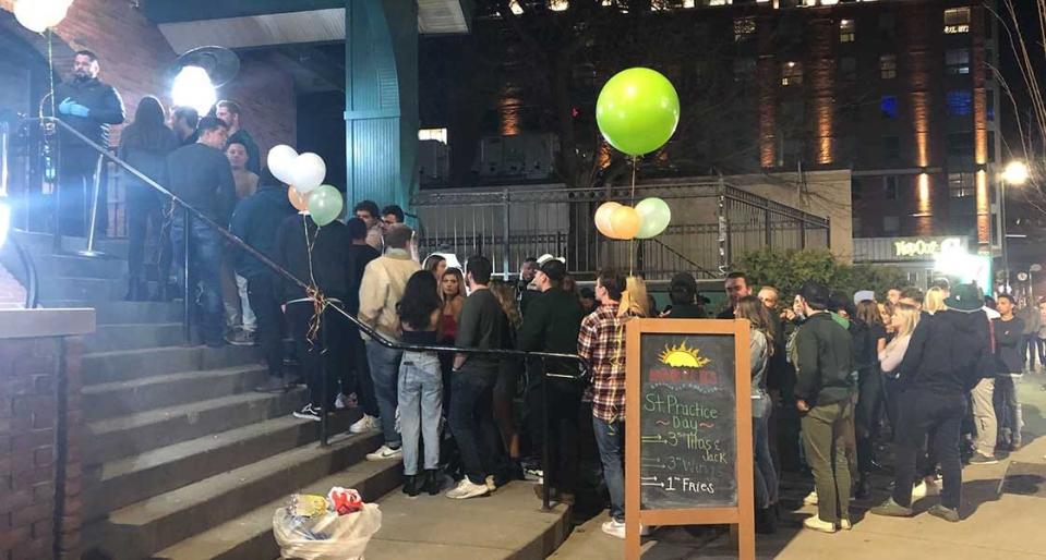 More than 50 people stood in line waiting to get into Harper’s in East Lansing, Mich., in late March, despite officials' warnings. Fourteen men and women who visited the brewpub in June have been confirmed to have the coronavirus.