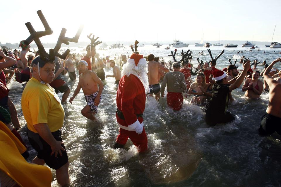 Participants run into English Bay during the 95th annual New Year's Day Polar Bear Swim in Vancouver, British Columbia