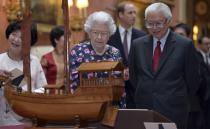 Britain's Queen Elizabeth and Singapore's President Tony Tan view a display of Singaporean items from the Royal Collection at Buckingham Palace in London October 21, 2014. The President of Singapore Tony Tan and his wife Mary Chee started a four day state visit to Britain on Tuesday. REUTERS/Anthony Devlin/Pool (BRITAIN - Tags: ENTERTAINMENT POLITICS ROYALS)