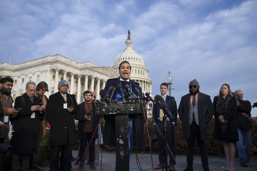 Rep. George Santos, R-N.Y., faces reporters at the Capitol in Washington, early Thursday, Nov. 30, 2023. After a scathing report by the House Ethics Committee citing egregious violations, Santos could be expelled from Congress this week. (AP Photo/J. Scott Applewhite)