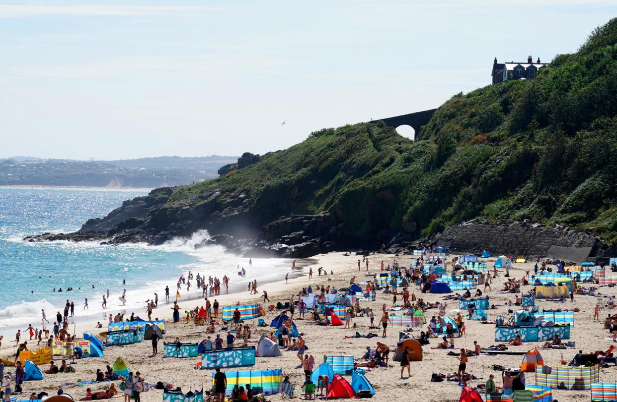 Groups of people relax on the beach in the sun on August 9, 2020 in St Ives, Cornwall, England: Getty Images