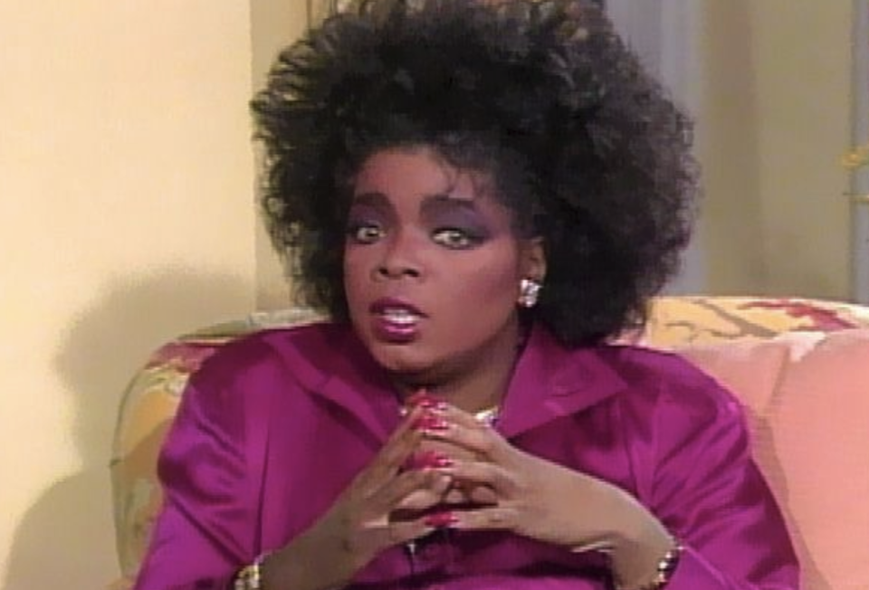 Oprah looking shocked with her fingers touching