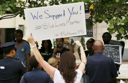 Police supporters (front) and counter demonstrators (rear) yell at each other as they are separated by a line of police during a "Blue Lives Matter" rally in support of the Baltimore police in front of City Hall in Baltimore, Maryland May 30, 2015. REUTERS/Jim Bourg