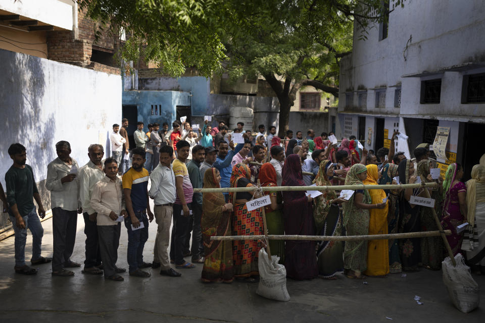 People stand in queue to vote during the third round of voting in the six-week-long general election in Agra, Uttar Pradesh, India, Tuesday, May 7, 2024. (AP Photo/Altaf Qadri)