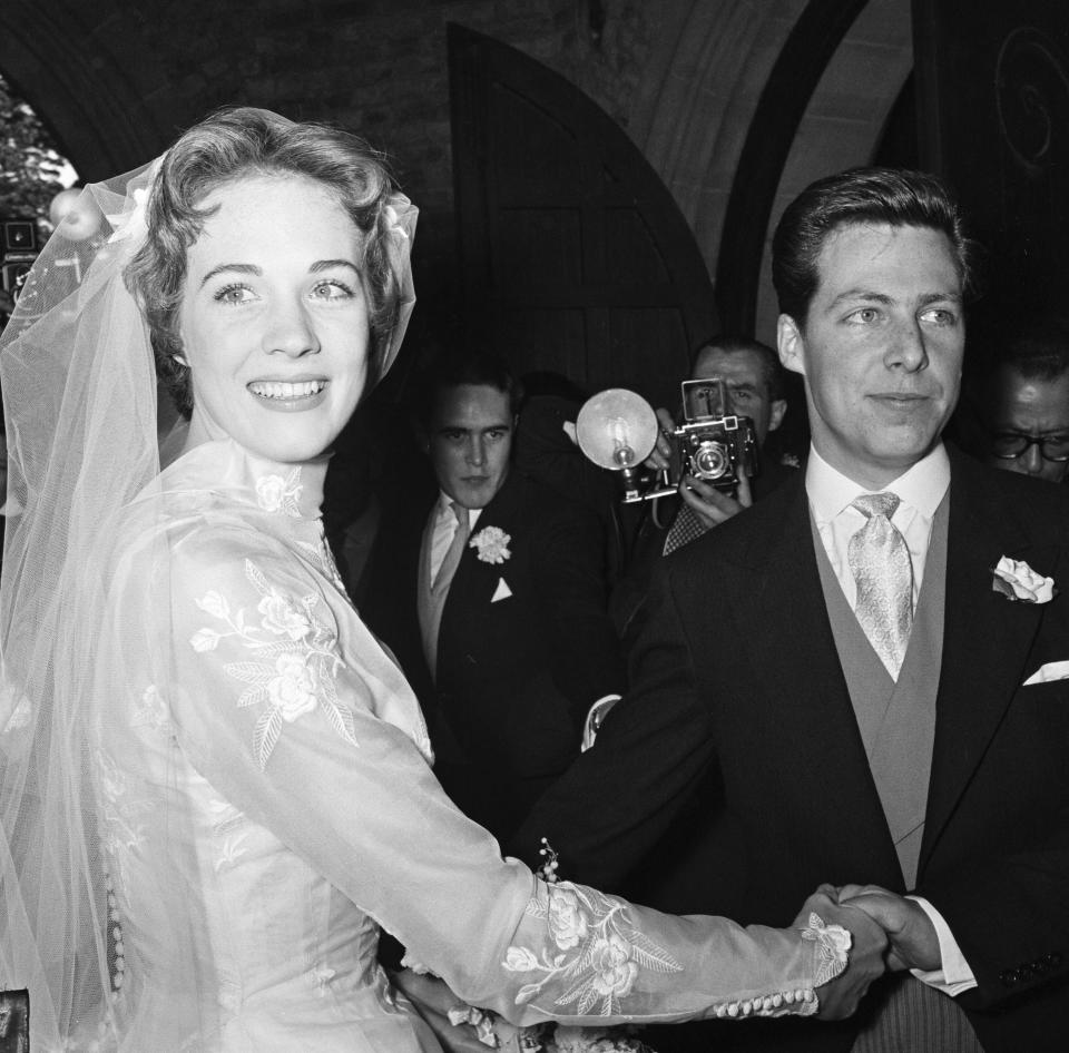 Julie Andrews smiles at the camera as she holds hands with her husband, Tony Walton..