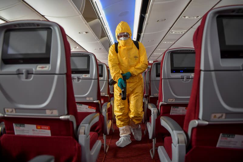 Man in protective suit works on disinfecting the aircraft cabin for a Hainan Airlines flight, as the country is hit by an outbreak of the novel coronavirus, at the Haikou Meilan International Airport in Haikou