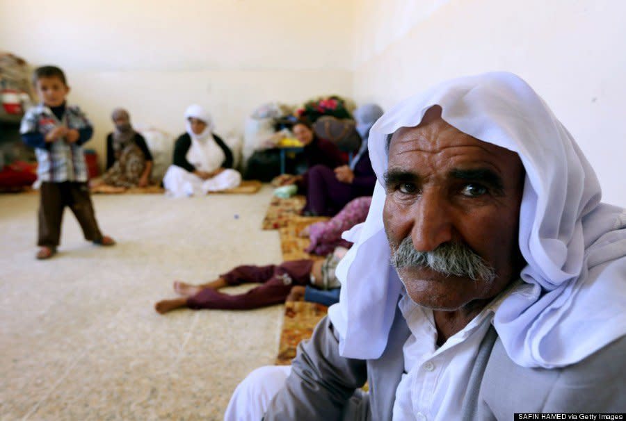 A Yazidi family that fled violence in northern Iraq sits at at a school where they are taking shelter in the Kurdish city of Dohuk on August 5, 2014. (SAFIN HAMED/AFP/Getty Images) 