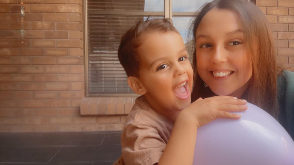 Milly Mitchell and her son George in front of a brick home.