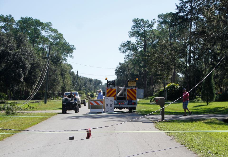 Musket Drive in the Itchepackesassa Creek area is blocked Saturday morning as a worker arrives to repair fallen power lines. Hurricane Ian snapped some wooden power poles in the area.