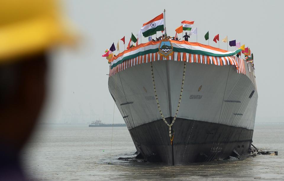 An Indian worker watches as INS Visakhapatnam, the first Indian Navy P15-B stealth destroyer, is launched in Mumbai on April 20, 2015. The indigenously-designed ships air defence capability is designed to counter the threat of enemy aircraft and anti-ship cruise missiles, and will revolve around a vertical launch and long-range surface-to-air missile system. The vessel is expected to be commissioned into the India Navy in 2018.  AFP PHOTO/ Indranil MUKHERJEE        (Photo credit should read INDRANIL MUKHERJEE/AFP via Getty Images)