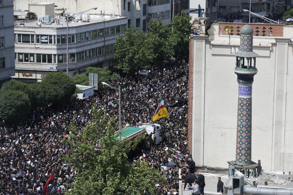 Iranians follow a truck carrying coffins of the late President Ebrahim Raisi and his companions who were killed in a helicopter crash on Sunday in a mountainous region of the country's northwest, during a funeral ceremony for them in Tehran, Iran, Wednesday, May 22, 2024. Iran's supreme leader presided over the funeral Wednesday for the country's late president, foreign minister and others killed in the helicopter crash, as tens of thousands later followed a procession of their caskets through the capital, Tehran. (AP Photo/Vahid Salemi)