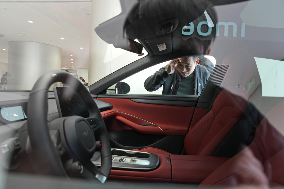A man peeks at the interior of the Xiaomi SU7 electric car on display in Beijing, Tuesday, March 26, 2024. Xiaomi, a well-known smart consumer electronics brand in China, is joining the country's booming but crowded market for electric cars. (AP Photo/Ng Han Guan)
