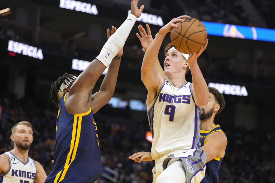 Sacramento Kings guard Kevin Huerter (9) drives to the basket against Golden State Warriors center Kevon Looney (5) during the first half of an NBA basketball game on Sunday, Oct. 23, 2022, in San Francisco. (AP Photo/Tony Avelar)