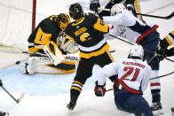 Washington Capitals' Nic Dowd (26) puts the puck behind Pittsburgh Penguins goaltender Casey DeSmith (1) for a goal during with Penguins' John Marino (6) defending during the first period of an NHL hockey game in Pittsburgh, Sunday, Jan. 17, 2021. (AP Photo/Gene J. Puskar)