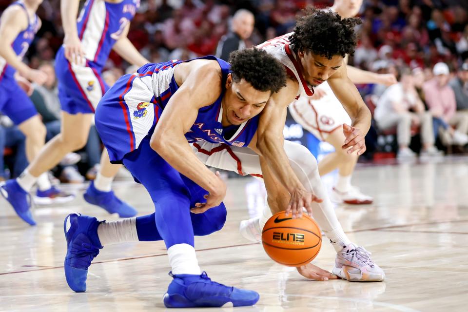 Oklahoma guard Milos Uzan (12) and Kansas guard Kevin McCullar Jr. (15) fight for the ball during a basketball game Saturday at the Lloyd Noble Center in Norman, Oklahoma.