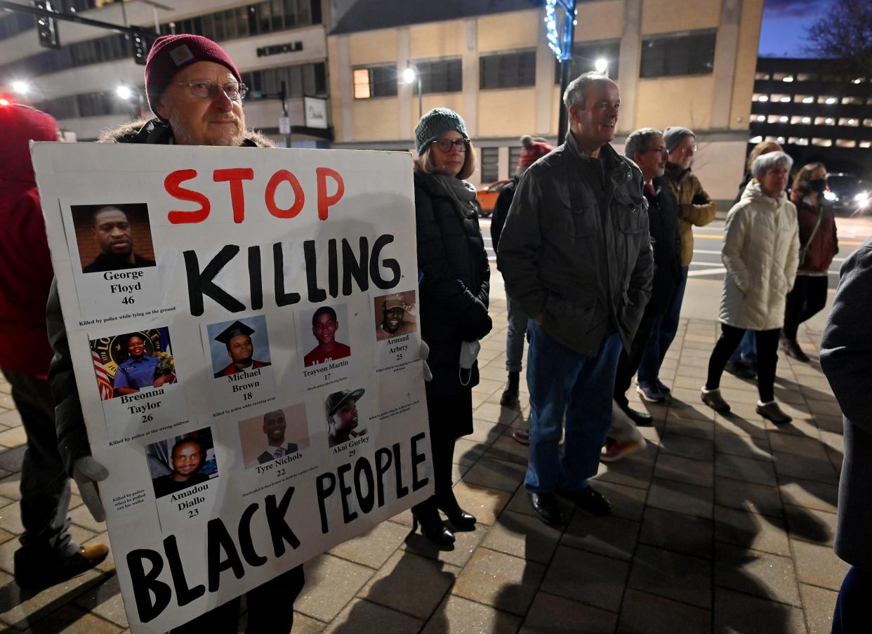 Activist Scott Schaeffer-Duffy holds a sign during a candlelight vigil Monday in memory of Tyre Nichols outside Worcester City Hall. Nichols, a Black man, was beaten by police officers Jan. 7 in Memphis, Tenn., and later died. The officers have been charged with second-degree murder.