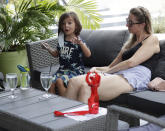 Wioletta Olivier, right, listens to her son Drake, 4, tell a story as they dine outside Aura at Books & Books, Monday, July 6, 2020, on Miami Beach, Florida's famed Lincoln Road. In Miami-Dade County, population 2.7 million, Mayor Carlos Gimenez ordered the closing of restaurants and certain other indoor places, including vacation rentals, seven weeks after they were allowed to reopen. Beaches will reopen on Tuesday after being closed over the weekend. (AP Photo/Wilfredo Lee)