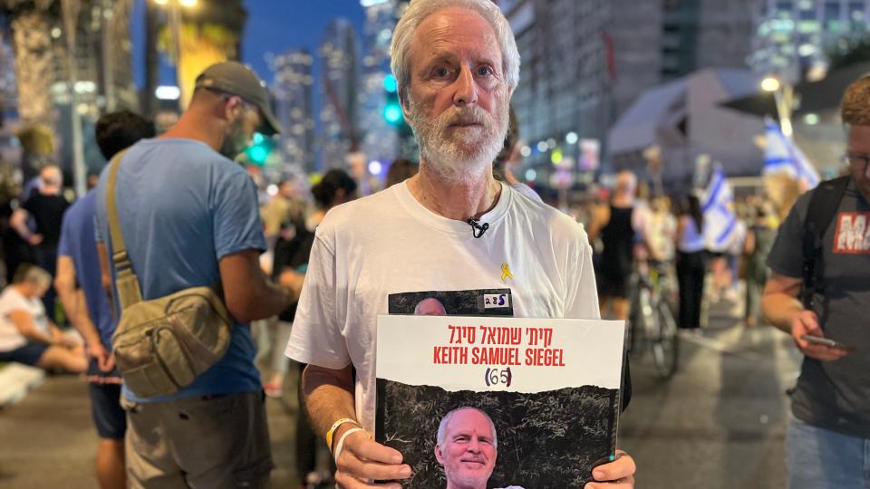 Lee Siegel holds poster showing his brother Keith's photo 