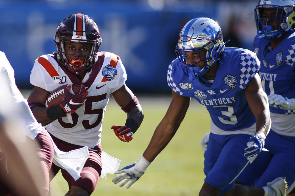 Virginia Tech running back Keshawn King, left, carries the ball as Kentucky safety Jordan Griffin (3) tries to make the tackle in the first half of the Belk Bowl NCAA college football game in Charlotte, N.C., Tuesday, Dec. 31, 2019. (AP Photo/Nell Redmond)