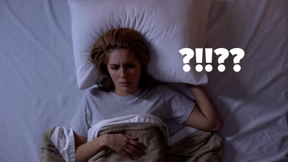 woman awake in bed looks worried