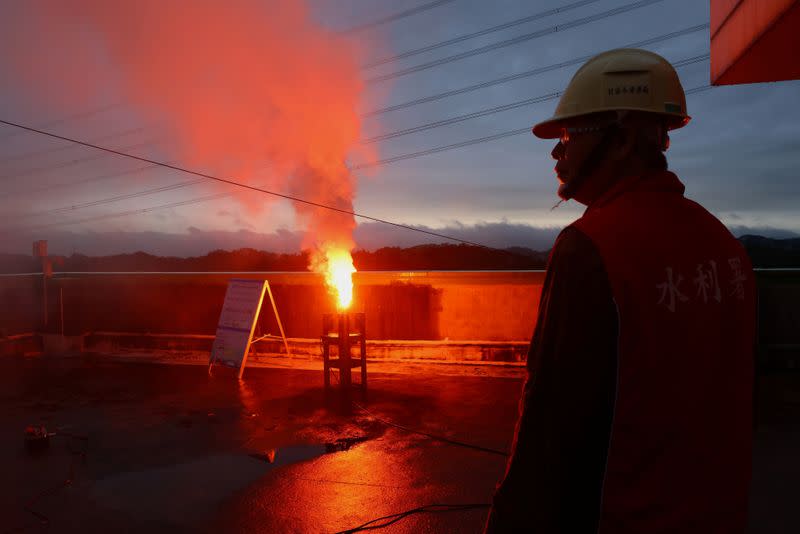 Staff member from the Water Resources Agency watches as chemicals are fired off into the air to stimulate rainfall amid an island-wide drought, at the Baoshan second reservoir in Hsinchu, Taiwan