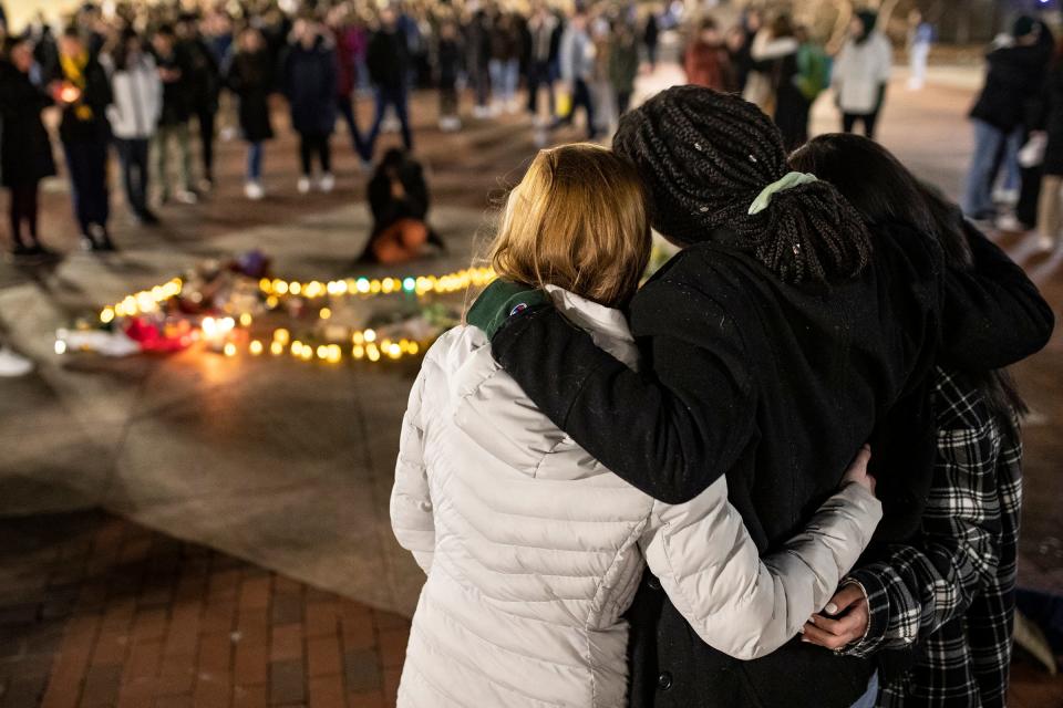 UM students comfort each other as they hold a candlelight vigil for MSU shooting victims at the Diag in Ann Arbor on Wednesday, Feb. 15, 2023.