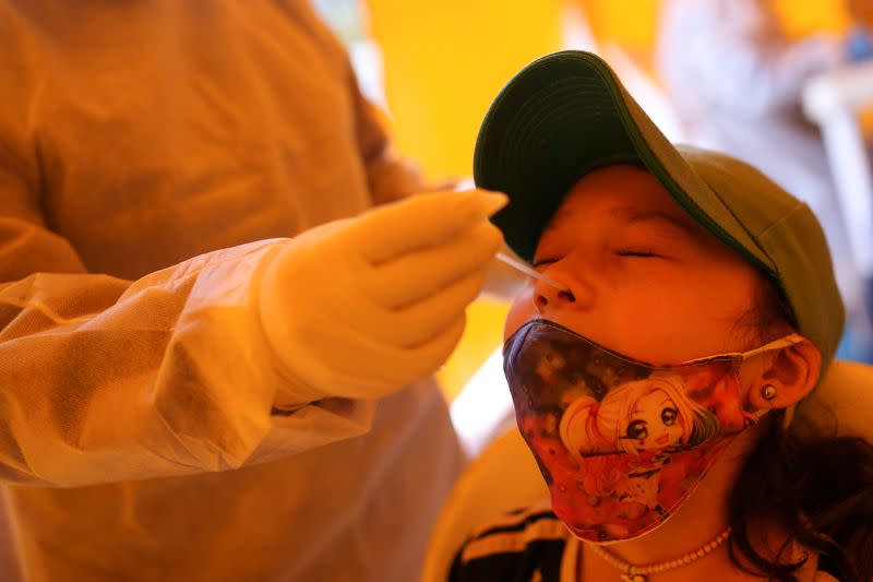 Foto de archivo. Un integrante de un equipo médico toma una muestra para detectar COVID-19 a una niña en Bogotá