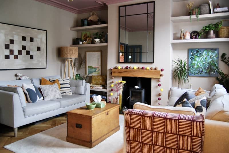 Living room with pink ceiling, large rectangular mirror, and matching grey couches.